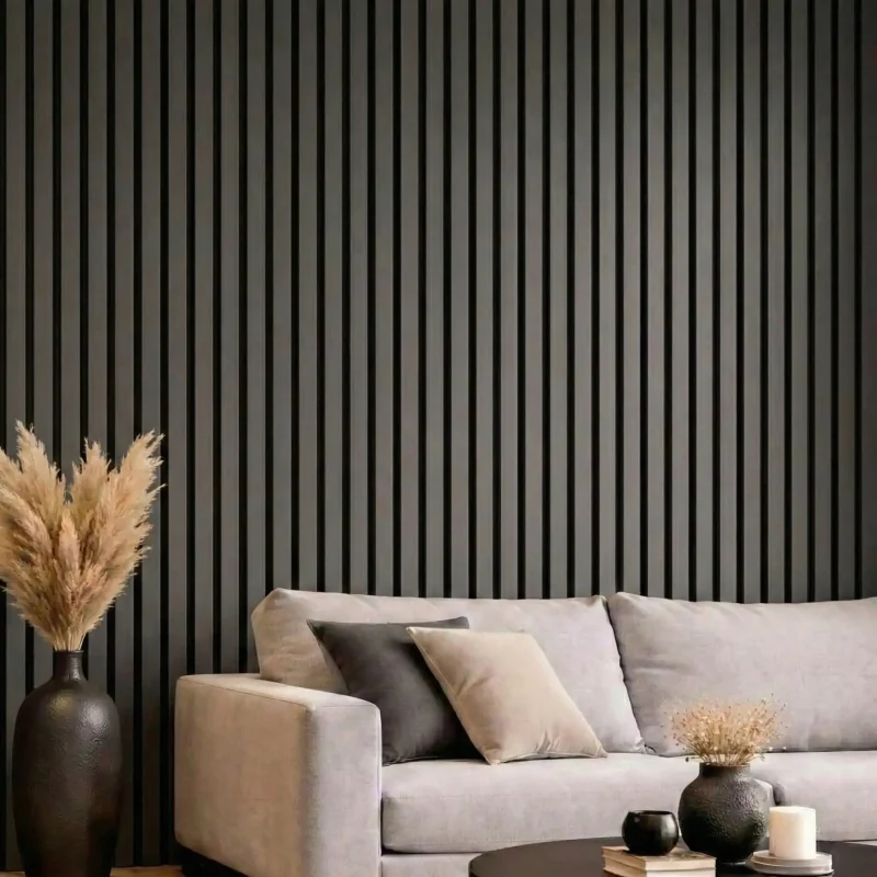 Dark grey acoustic slat wood panels feature wall in a modern living room with natural light and grey sofa.