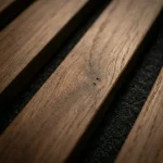 Smoked oak acoustic slat wood panel close up detail of natural grain and black felt backing.