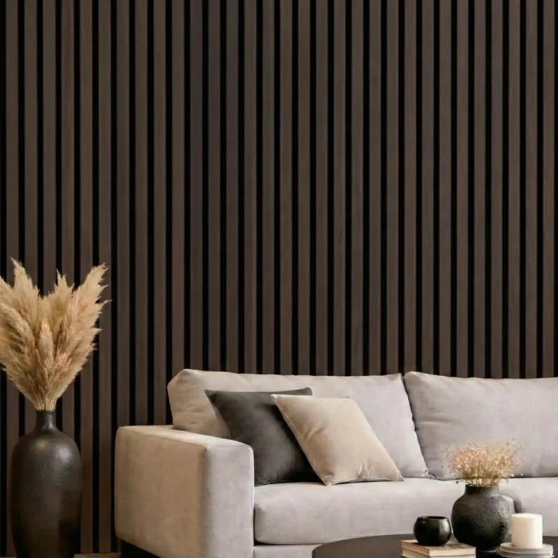 Smoked oak acoustic slat wood panels installed as a feature wall behind a grey sofa in a modern lounge.