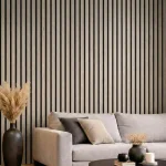 Light grey acoustic slat wood panels installed as a feature wall behind a grey sofa in a modern lounge.